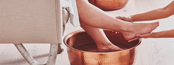 A luxurious foot treatment at The Bamford Wellness Spa at The Berkeley. The guest's foot is held aloft over a copper bowl.