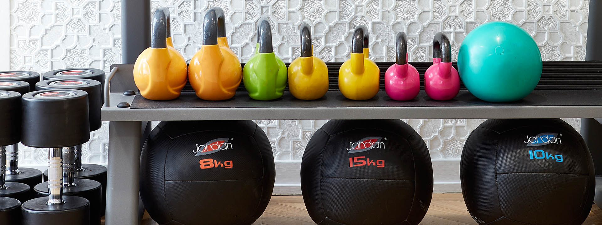 A row of kettle bells and medicine balls